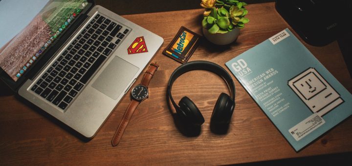 MacBook Pro beside cordless headphones