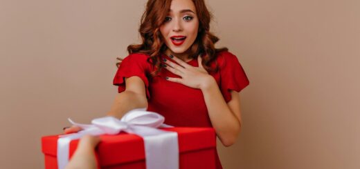 a woman in a red dress holding a red gift box
